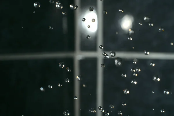 Gotas caen sobre un fondo negro. —  Fotos de Stock