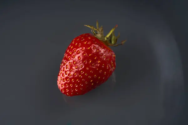 짙은 회색 배경에 있는 딸기 한 장. — 스톡 사진