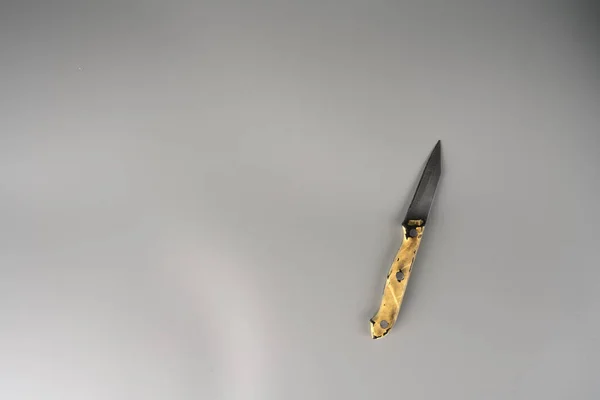 Uma pequena faca afiada velha em um fundo cinza. — Fotografia de Stock