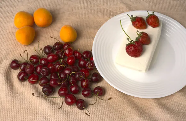 A large white ice cream is lying and strawberries are lying on a white plate — Stock Photo, Image