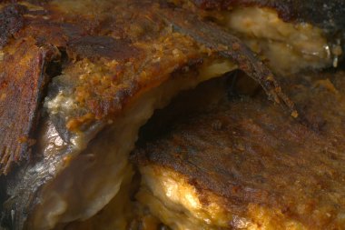 Kızartma tavasında kızartılmış balık büyük sazan balığı. Beyaz arka planda altın bir tonda.