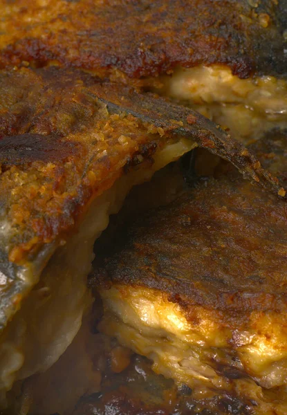 Peixe grande carpa frita em uma frigideira com uma tonalidade dourada em um fundo branco close-up. — Fotografia de Stock