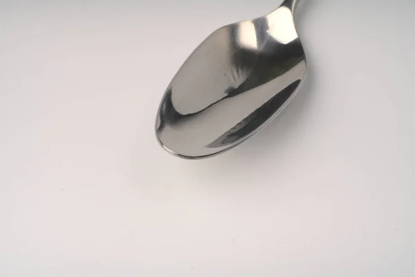 Metallic spoon on a white background closeup. — Stock Photo, Image