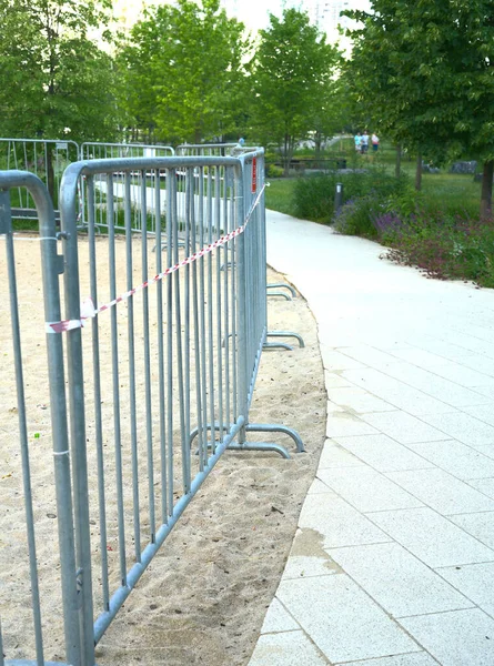 L'aire de jeux est clôturée avec des barrières métalliques en raison de mesures restrictives liées à la pandémie de Covid — Photo
