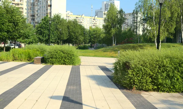 Uma praça pavimentada em pedra em um parque da cidade de verão. — Fotografia de Stock