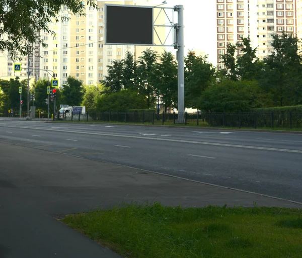 Eine menschenleere Straße am frühen Morgen mit einem Werbeplakat für eine Attrappe. — Stockfoto