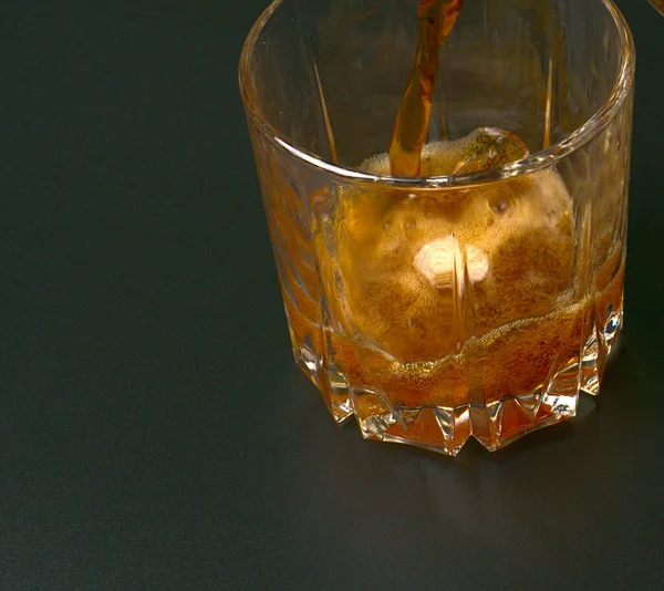 We pour refreshing soda into a transparent glass on a black background. — Stock Photo, Image