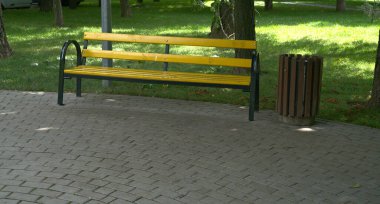 Şehir parkında bir bank ve bir vazo..