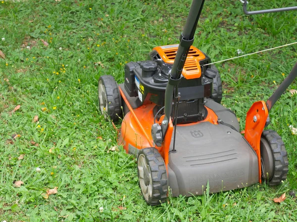 Moscow, Russia - june 20 2020: The orange branded lawn mower stands on the green grass in summer — Stock Photo, Image