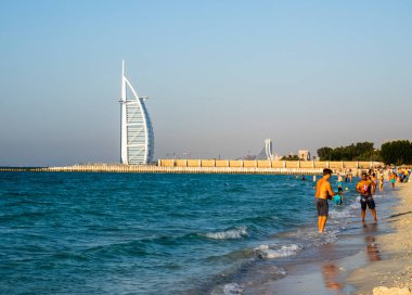 Dubai 'nin turistleri ve sakinleri Burj Al Arab' ın yanındaki plajda güneşli bir günün tadını çıkarıyorlar.