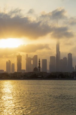 Dubai, BAE - 03.06.2021 Dubai halk plajı. Arkaplanda şehir silüeti var. Gün doğumu saati.