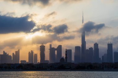 Dubai, BAE - 03.06.2021 Dubai halk plajı. Arkaplanda şehir silüeti var. Gün doğumu saati.