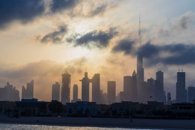 Dubai, BAE - 03.06.2021 Dubai halk plajı. Arkaplanda şehir silüeti var. Gün doğumu saati.