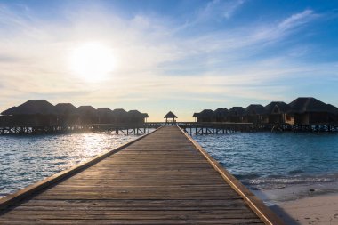 Tropikal adada su üstünde bir bungalovun çekimi