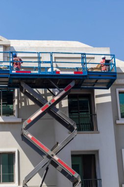 Yükseklerde çalışan bir bakım işçisinin, binanın ön cephesini onarırken vurulması