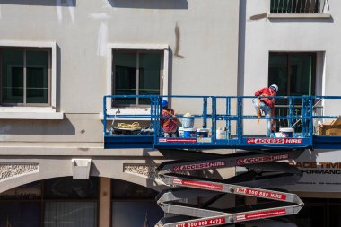 Dubai, BAE - Yükseklerde çalışan bir bakım işçisinin vurulması, Uluslararası şehir bölgesindeki binanın ön cephesinin onarılması.