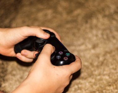 Oyun kontrolörüyle ellerin yakın çekim görüntüsü.