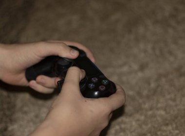 Oyun kontrolörüyle ellerin yakın çekim görüntüsü.