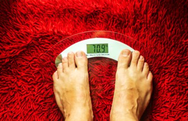 Şeffaf ölçekte orta yaşlı bir adamın çıplak ayakları.