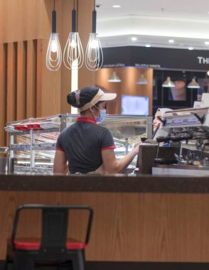 Dubai, BAE - 07.17.2021 Dubai alışveriş merkezinde servis yapan bir baristanın fotoğrafı.