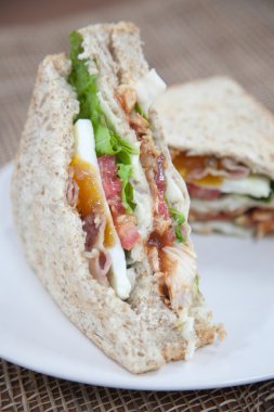 Beyaz bir tabak üzerinde hizmet sandviç. 