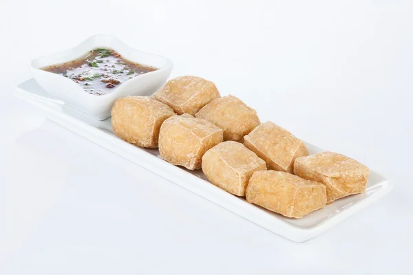 Tatlı ve ekşi soslu beyaz çanak üzerinde derin kızarmış Tofu.