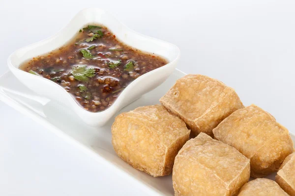 Tatlı ve ekşi soslu beyaz çanak üzerinde derin kızarmış Tofu.