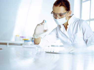 Kadın laboratuvar asistanı hastanede kan örneğini inceliyor. Tıp, sağlık ve araştırma konsepti