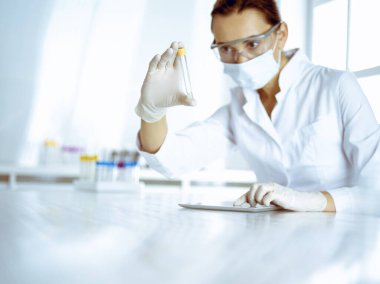 Kadın laboratuvar asistanı hastanede kan örneğini inceliyor. Tıp, sağlık ve araştırma konsepti