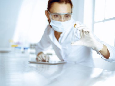 Kadın laboratuvar asistanı hastanede kan örneğini inceliyor. Tıp, sağlık ve araştırma konsepti