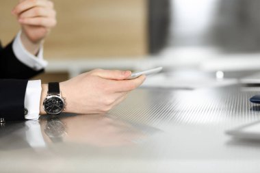 Meçhul iş adamları ve kadınlar modern ofiste oturuyorlar, çalışıyorlar ve sorularını tartışıyorlar.