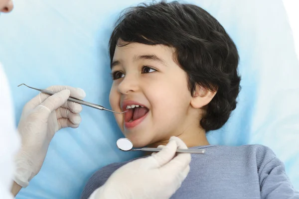 Cute árabe menino sentado na cadeira dentária com a boca aberta durante a verificação oral com o médico. Consulta ao dentista. Conceito de estomatologia — Fotografia de Stock