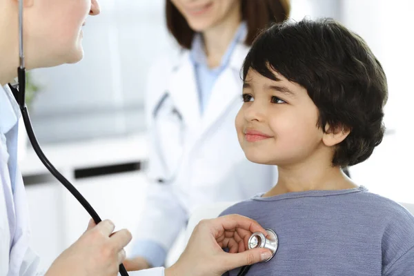 Dokter-vrouw die een kindpatiënt onderzoekt met stethoscoop. Leuke Arabische jongen op afspraak bij de dokter. Geneesmiddelenconcept — Stockfoto