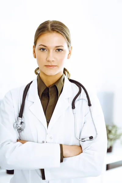 Mujer-médico de pie con los brazos cruzados y mirando a la cámara. Servicio médico perfecto en la clínica — Foto de Stock