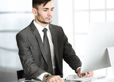 Modern ofiste bilgisayarla çalışan bir iş adamı. İş yerindeki erkek girişimci ya da yönetici. İş konsepti