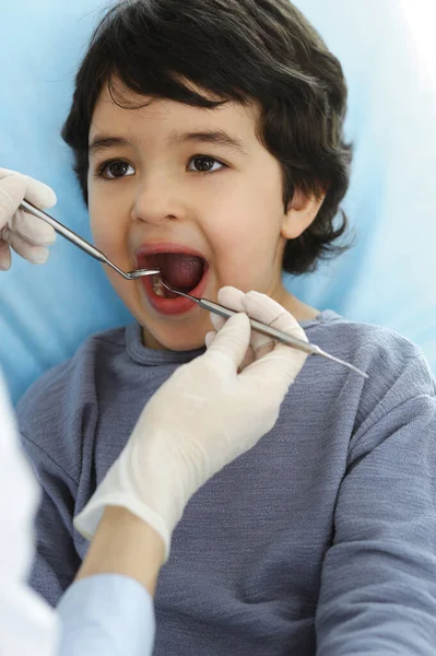 Μικρό αγόρι Άραβας κάθεται στην οδοντιατρική καρέκλα με ανοιχτό το στόμα κατά τη διάρκεια του στοματικού ελέγχου με οδοντίατρο. Στοματολογία έννοια — Φωτογραφία Αρχείου