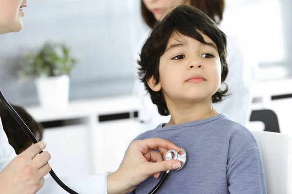 Docteur-femme examinant un enfant patient par stéthoscope. Joli garçon arabe sur rendez-vous chez le médecin. Concept de médecine — Photo