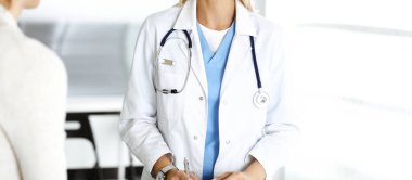 Bilinmeyen kadın-doktor kadın hastayla iletişim kuruyor. Doktor tıbbi geçmişi ve muayene sonuçlarını yakından kontrol ediyor. Tıp konsepti