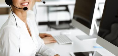 Bilinmeyen kadın müşteri hizmetleri temsilcisi kulaklık kullanarak müşterilere danışmanlık yapıyor. Yakın plan. Çağrı merkezi ve iş konsepti
