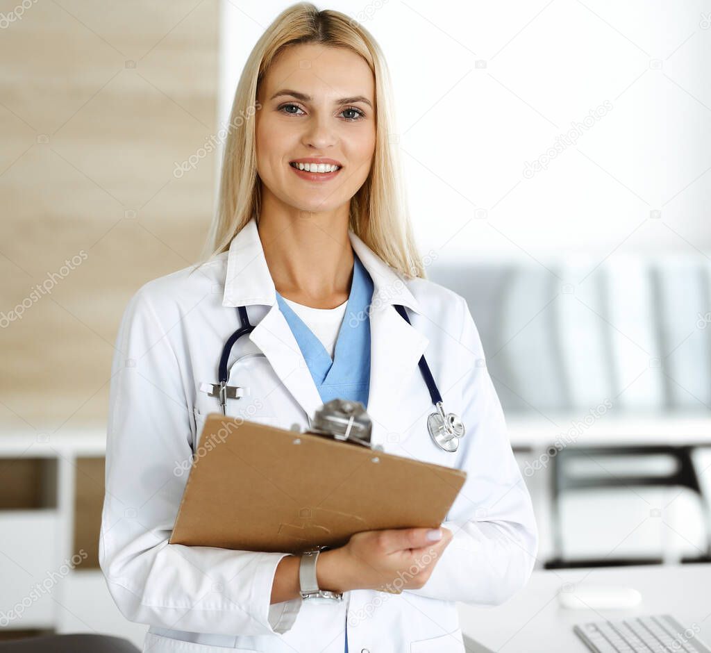 Doctor woman at work in hospital controls medication history records and exam results while using clipboard. Medicine and healthcare concept
