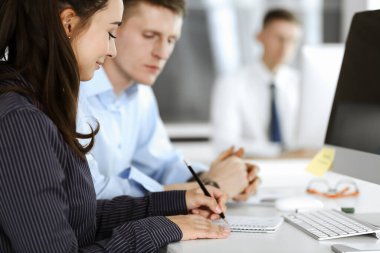 İş kadını ve erkek, modern ofiste bilgisayar kullanırken soruları tartışıyorlar. Takım çalışması, toplantı ve beyin fırtınası konsepti