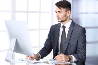 Modern ofiste bilgisayarla çalışan bir iş adamı. Arap erkek girişimcinin ya da iş yerindeki müdürün vesikalığı. İş konsepti