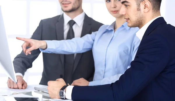 Groep van diverse zakenmensen bespreken vragen bij een ontmoeting in het moderne kantoor. Collega 's die op de werkplek met computers werken. Multi-etnische teamwork en business concept — Stockfoto