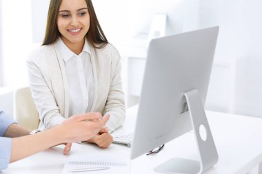 İş kadını ve erkek ofiste bilgisayar başında oturuyor ve çalışıyor. İş arkadaşları toplantıda bir şey tartışıyor. Şirket takım çalışması ve ortaklık kavramları