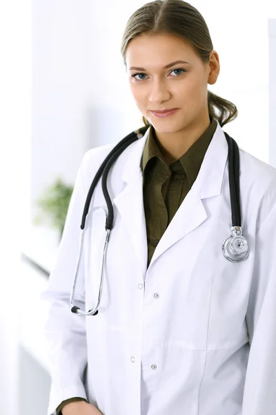 Γιατρός γυναίκα στέκεται ευθεία και κοιτάζοντας την κάμερα. Τέλεια ιατρική υπηρεσία στην κλινική. Ευτυχές μέλλον στην ιατρική και την υγειονομική περίθαλψη — Φωτογραφία Αρχείου