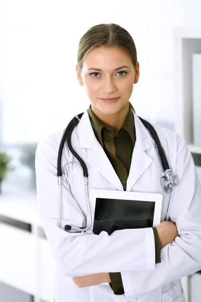 Женщина-доктор стоит прямо и смотрит в камеру. Идеальное медицинское обслуживание в клинике. Счастливого будущего в медицине и здравоохранении — стоковое фото