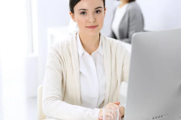 Mujer de negocios que trabaja con la computadora en la oficina, colega de fondo. Imagen de Abogado o Contador en el trabajo mientras está sentado en el escritorio —  Fotos de Stock