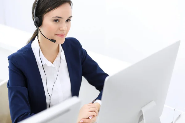 Centro de llamadas. Hermosa recepcionista mujer sentada en auriculares en la oficina de servicio al cliente. Grupo de operadores en el trabajo. Concepto empresarial —  Fotos de Stock