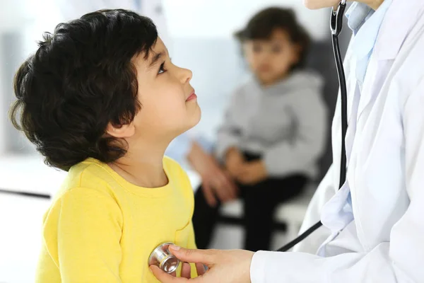 Врач осматривает ребенка стетоскопом. Милый арабский мальчик на приеме у врача. Медицина и здравоохранение — стоковое фото
