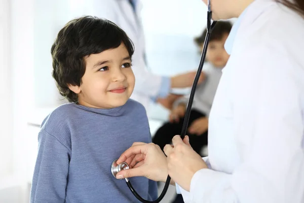 Médico examinando a un niño paciente por estetoscopio. Lindo chico árabe en la cita con el médico. Concepto de medicina y salud — Foto de Stock